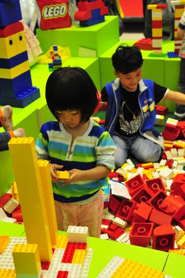 小朋友沉浸在樂(lè)高積木的世界里，專心致志地拼搭自己的作品。