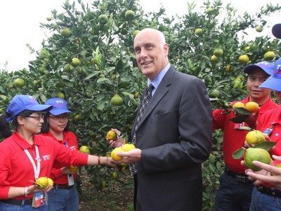 沃爾瑪中國公司事務(wù)高級副總裁博睿（中）考察大理項目基地，并同沃爾瑪員工志愿者一起幫助受助農(nóng)戶收獲成熟的柑橘。