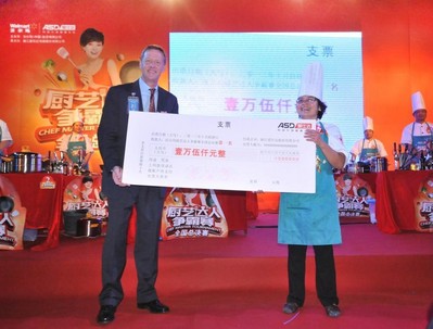 沃爾瑪中國(guó)大賣(mài)場(chǎng)采購(gòu)部非食品采購(gòu)副總裁施德威（左）為沃爾瑪廚藝達(dá)人爭(zhēng)霸賽全國(guó)決賽冠軍（右）頒發(fā)15000元現(xiàn)金大獎(jiǎng)